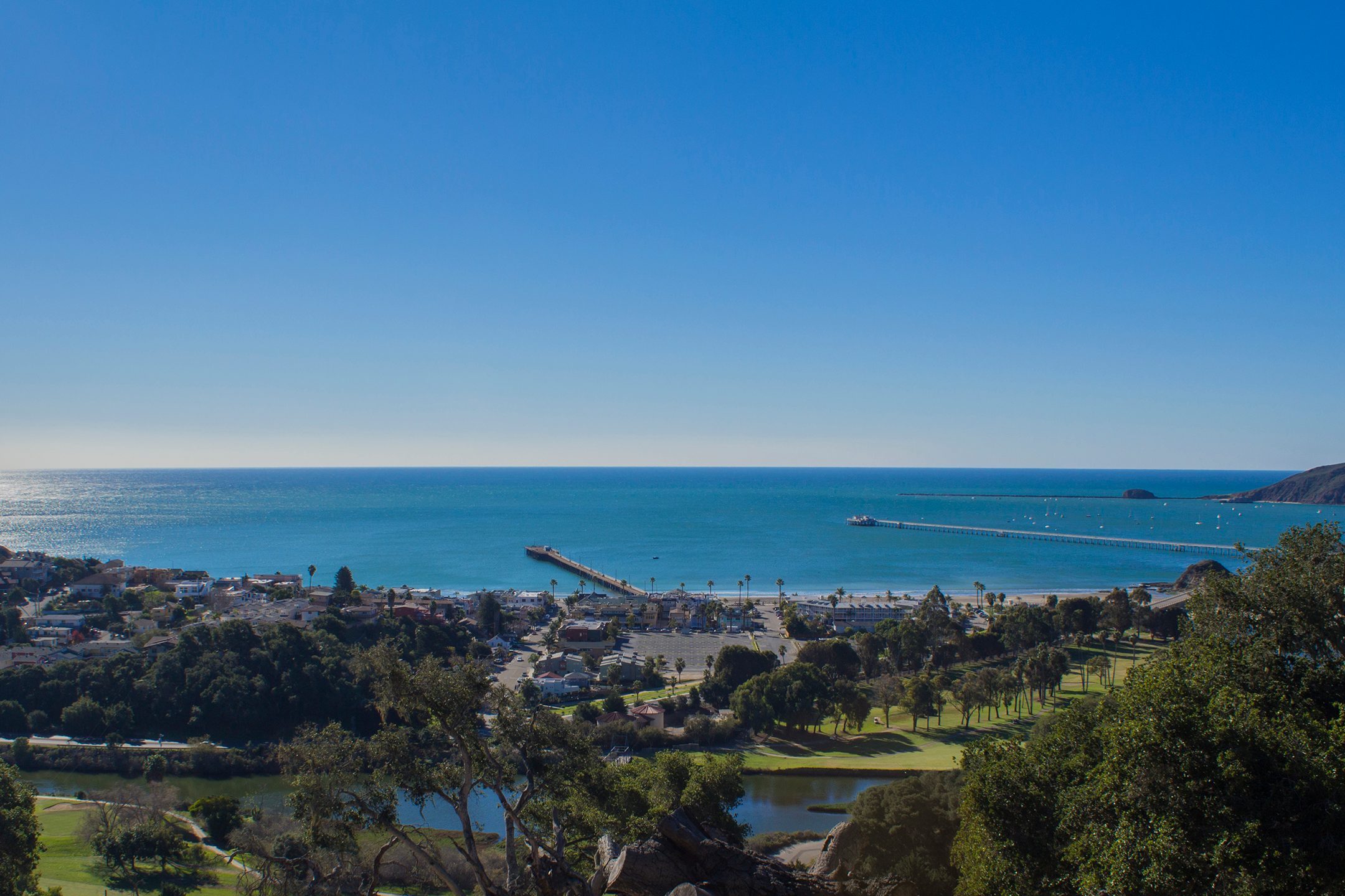 Wide view of Avila Beach, both piers and San Luis Bay from the hills above the golf course