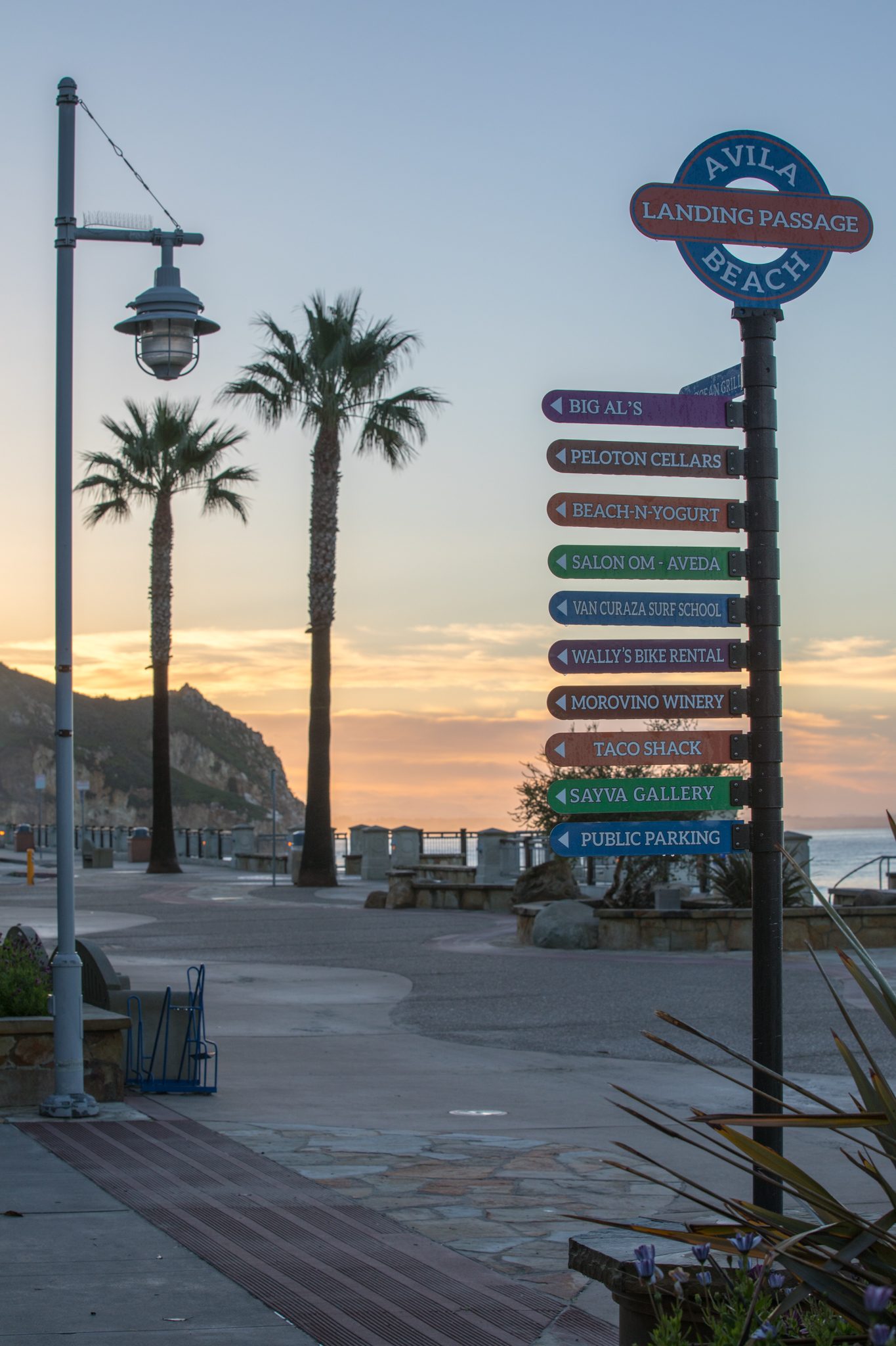 The Landing Passage sign pointing to shops, restaurants and parking on the promenade at dawn