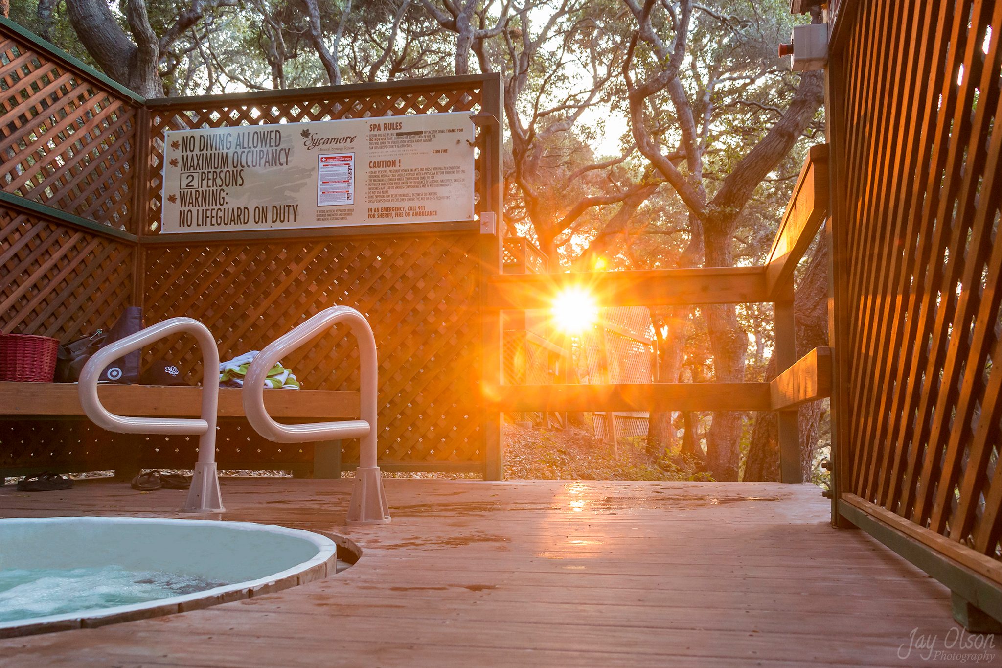 A private hot tub on a deck among the oaks at Sycamore Mineral Springs, the sun low through the trees