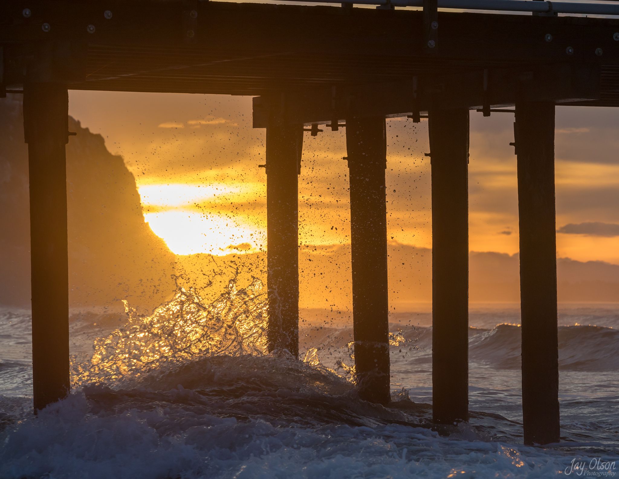 A wave rolling under the pilings of Avila Pier