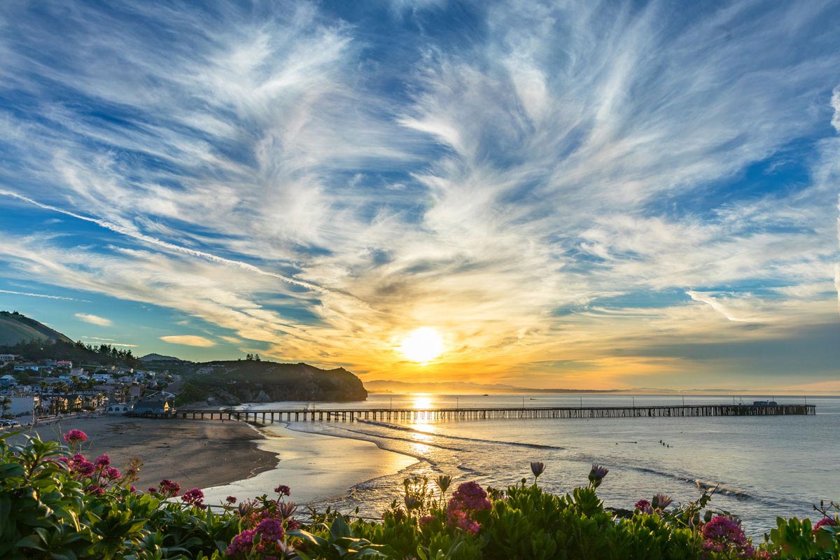 Wispy morning clouds over flowers and the town of Avila Beach