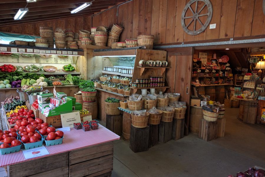 Tomatoes, vegetables, jams and baskets inside Avila Valley Barn, with the country store beyond