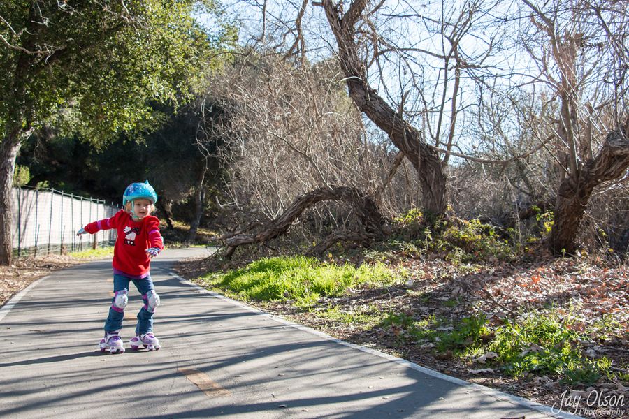 A young child in a helmet roller skating on the Bob Jones Trail