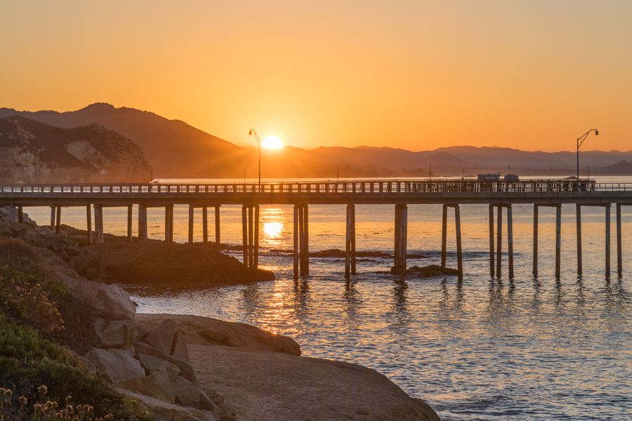 The sun rising over the hills behind Harford Pier, seen from the rocks at Port San Luis