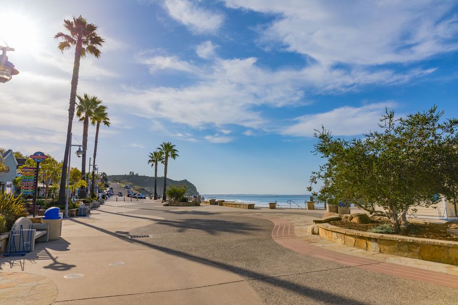 The palm-lined promenade along Front Street, with the Landing Passage shop sign and the beach