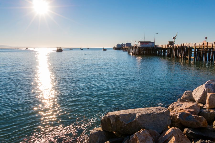 The sun glittering on the water beside Harford Pier and its sportfishing office
